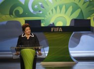 Dilma Rouseff_in_front_of_FIFA_logo