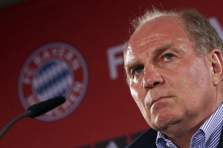 Uli Hoeness_in_front_of_Bayern_Munich_logo