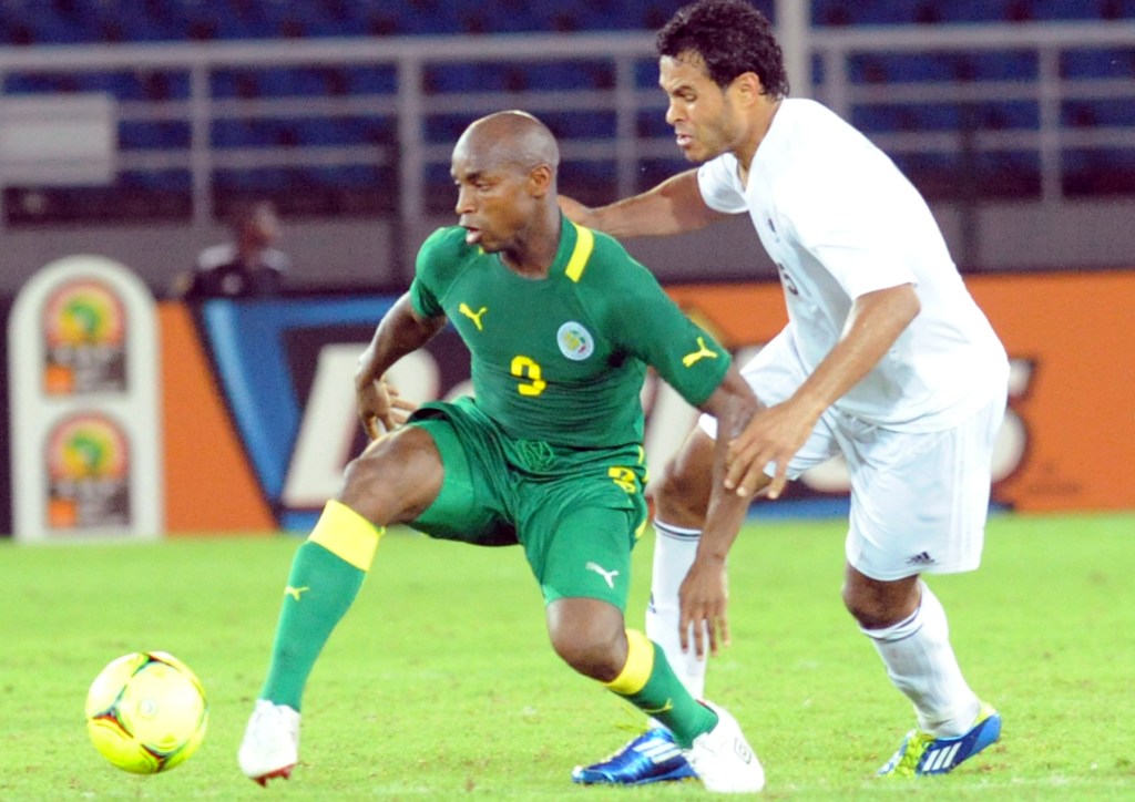 Soulaymane Camara_L_vies_for_the_ball_with_Libyas_Younes_Shibani_R_25-04-12