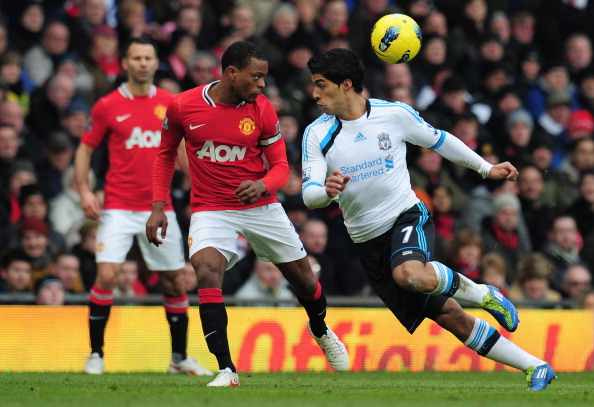 Patrice Evra_heads_the_ball_away_from_Luis_Suarez